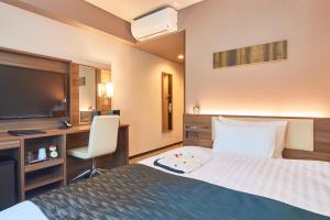 Tempat tidur dalam kamar di &and COMFY HOTEL Kumamoto Jo View