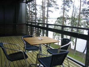 a table and chairs on a porch with a view of the water at Kuortaneen Urheiluopisto in Kuortane