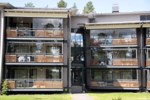 an apartment building with large windows and a dog on the balcony at Kuortaneen Urheiluopisto in Kuortane