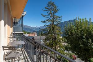 einen Balkon mit Blick auf einen Baum und die Berge in der Unterkunft Apartment & studio Leysin Sport Hôtel in Leysin