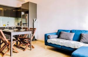 een woonkamer met een blauwe bank en een tafel bij 2 Bedroom 2 BATHROOM NEAR SUMWAY PYRAMID in Subang Jaya