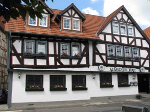 a black and white building with flowers in the windows at Restaurant / Pension Mainzer Tor in Alsfeld