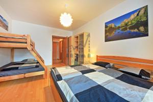 a bedroom with two bunk beds and a staircase at St. Peter Apartment in Špindlerův Mlýn