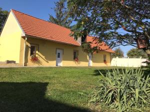 ein kleines gelbes Haus mit rotem Dach in der Unterkunft U Pichlerů in Klipec