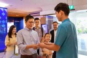 新加坡Ibis Styles Singapore On Macpherson的一群人站在一个房间里站在一个人周围