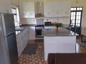 a kitchen with white cabinets and a refrigerator at Madison guest house in Nanyuki