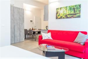 uma sala de estar com um sofá vermelho e uma mesa em Realkasa Azzarita Flat em Bolonha