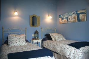 two beds in a bedroom with blue walls at Hotel Rural El Marquesito Antigua Casa Carmela in Arenas de San Pedro