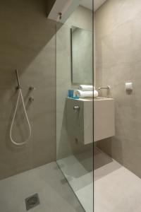 a bathroom with a glass shower and a sink at Hippocrates - Faliro deluxe apartment in Athens