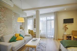 een woonkamer met een bank en een tafel bij Valensia Apartment in Druskininkai