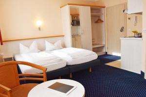 a hotel room with a bed and a table and a chair at Mikro Apartments Erding in Erding