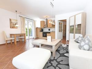 Una sala de estar con un sofá blanco y una mesa. en Ferienwohnung Ostseebrise, en Thiessow