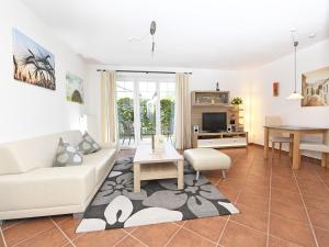 una sala de estar con un sofá y una mesa en Ferienwohnung Ostseebrise, en Thiessow