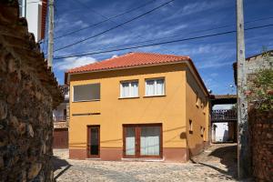 uma casa amarela com um telhado vermelho em Casa da Avó Amália em Janeiro de Cima
