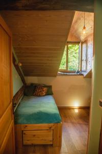 een kleine kamer met een bed in een tiny house bij The Dragon Barn - Grenier in Ascou