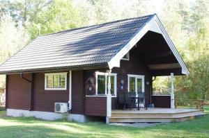 een klein huis met een veranda en een terras bij Tallbarren in Rälla