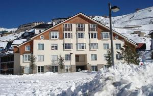 a large building with a lot of snow in front of it at GRAN ESTUDiO MARIBEL in Sierra Nevada