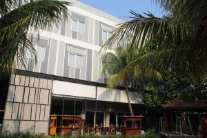 a building with palm trees in front of it at Greenotel Cilegon in Cilegon
