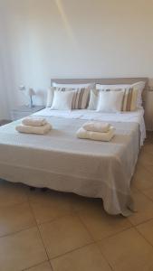 1 cama grande con 2 toallas encima en B&B Villa Orchidea, en Olbia