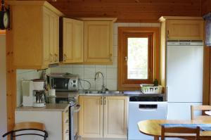 - une cuisine avec des placards en bois et un réfrigérateur blanc dans l'établissement Tallbarren, à Rälla