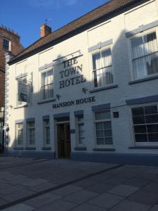 un edificio blanco con un cartel que lee el hotel de la ciudad en The Town Hotel, en Bridgwater