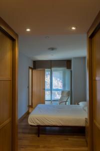 イルンにあるBidasoa by Basquelidaysのベッドルーム1室(ベッド1台、椅子、窓付)
