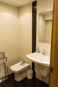La salle de bains blanche est pourvue d'un lavabo et de toilettes. dans l'établissement Bidasoa by Basquelidays, à Irún