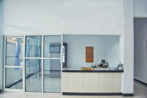 a kitchen with a counter and a glass door at SUPER OYO 1565 Hotel Homiko in Pacitan
