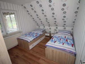 1 dormitorio con 2 camas individuales en una habitación en Ferienwohnung am Kaiserwald, 15191 en Leer