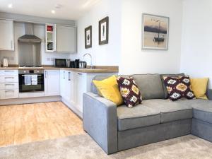 a living room with a couch and a kitchen at The Martins in Peterborough