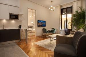 een woonkamer en een keuken met een bank en een tafel bij SY Fuencarral in Madrid