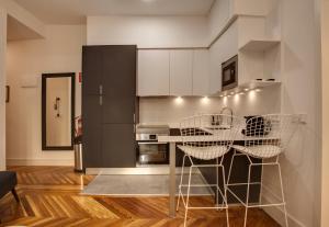 een keuken met een tafel met stoelen en een koelkast bij SY Fuencarral in Madrid