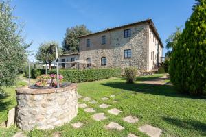 una casa de piedra con una pared de piedra en el patio en Le Rocche Di Valiano, en Valiano 