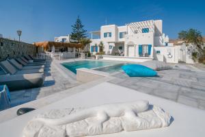 a villa with a swimming pool and a building at Gelos House in Ornos