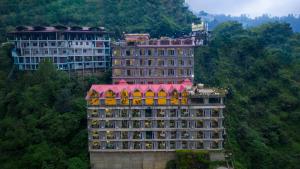 a large building with a red roof on a mountain at Snow Valley Resorts Shimla in Shimla