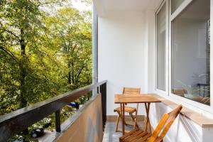 een balkon met een houten tafel en 2 stoelen bij Apartments Warsaw Franciszkańska in Warschau