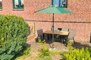 ein Tisch und Stühle mit einem grünen Sonnenschirm in der Unterkunft Ferienwohnung Zudar auf Rügen in Zudar