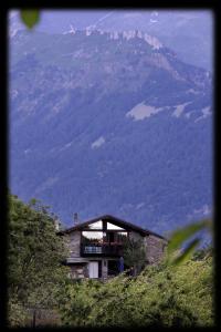 un edificio en una colina con vistas a una montaña en Alla Bastilla B&B, en Gravere