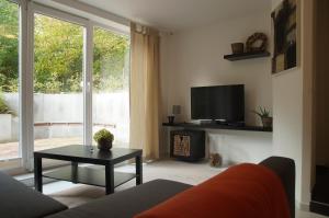 ein Wohnzimmer mit einem Sofa, einem TV und einem Tisch in der Unterkunft Haus Lüllmann in Bremen