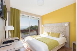 a bedroom with a large bed and a large window at Hôtel-Restaurant Bois Joly in Crozet