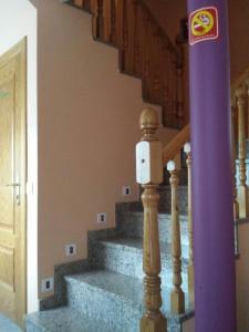 un poste púrpura con un letrero al lado de una escalera en Hostal Vaticano, en Alfajarín