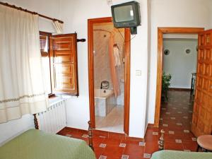 a bathroom with a shower and a television in it at Mesón de Lagartera in Lagartera