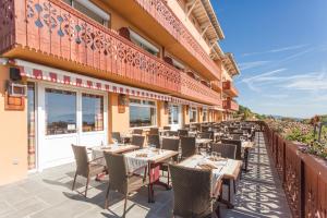 eine Terrasse eines Restaurants mit Tischen und Stühlen in der Unterkunft Hôtel-Restaurant Bois Joly in Crozet