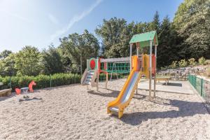 um parque infantil com escorrega na areia em Hôtel-Restaurant Bois Joly em Crozet