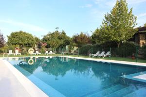 a large swimming pool with chairs in a yard at Veragua. Glamping y Apartamentos turísticos in Villanueva de la Vera