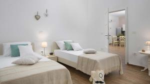 a white bedroom with two beds and a bathroom at Charming villa Tartufo with private pool near Pula in Svetvinčenat +9 photos