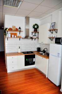 a kitchen with white appliances and a wooden floor at Studio D&T in Slavonski Brod