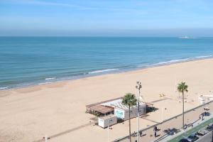 una vista aérea de una playa con palmeras y un edificio en Casa Brasil - 1ª Linea Playa con Parking Incluido, en Cádiz