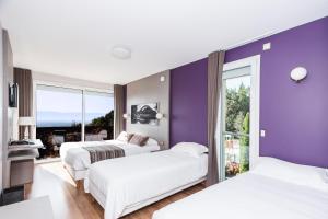 1 dormitorio con 2 camas y pared púrpura en Hôtel-Restaurant Bois Joly en Crozet