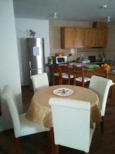 cocina con mesa, sillas y nevera en Casa do Azibo, en Santa Combinha